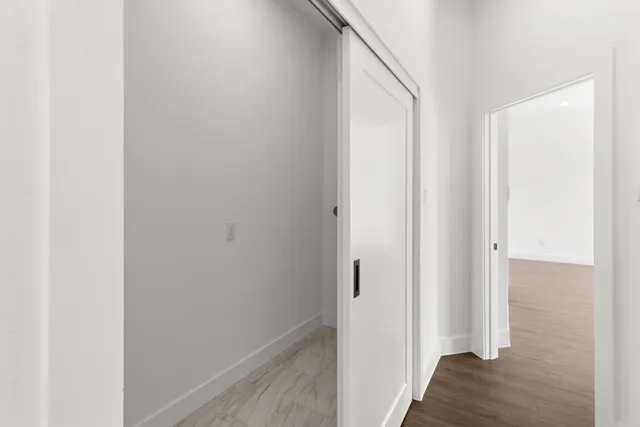 a view of a hallway with wooden floor
