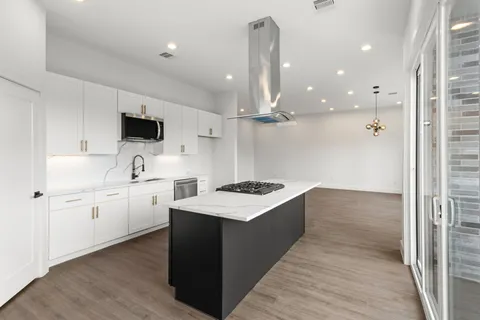 a kitchen with white cabinets appliances and sink