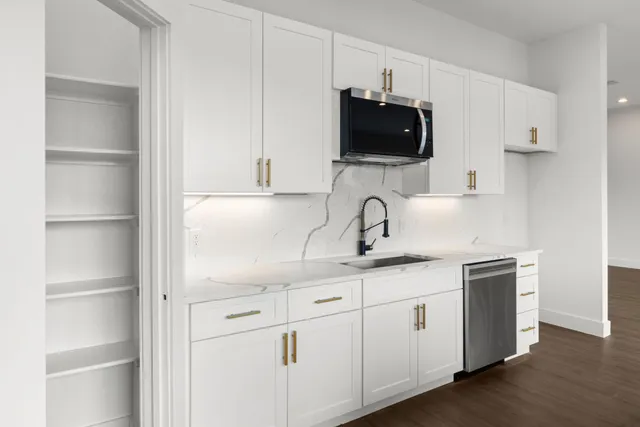a kitchen with stainless steel appliances granite countertop a sink and a microwave