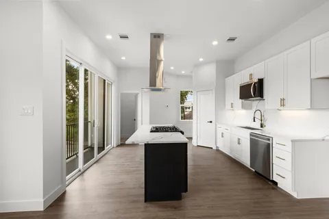 a kitchen with stainless steel appliances kitchen island granite countertop a stove a sink and a refrigerator