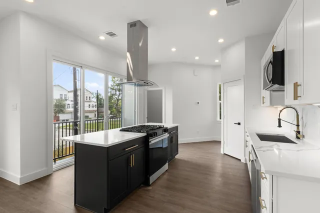 a kitchen with granite countertop a sink and a stove top oven