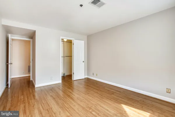 an empty room with wooden floor and closet