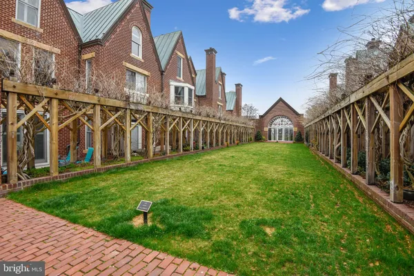 a view of a big house with a big yard and potted plants