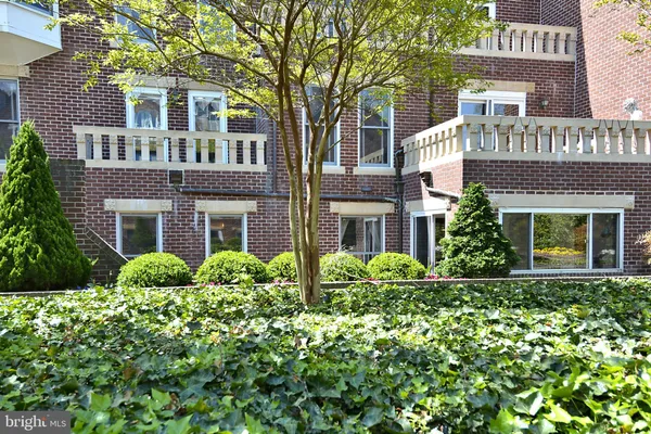 a front view of multi story residential apartment building with retail shops
