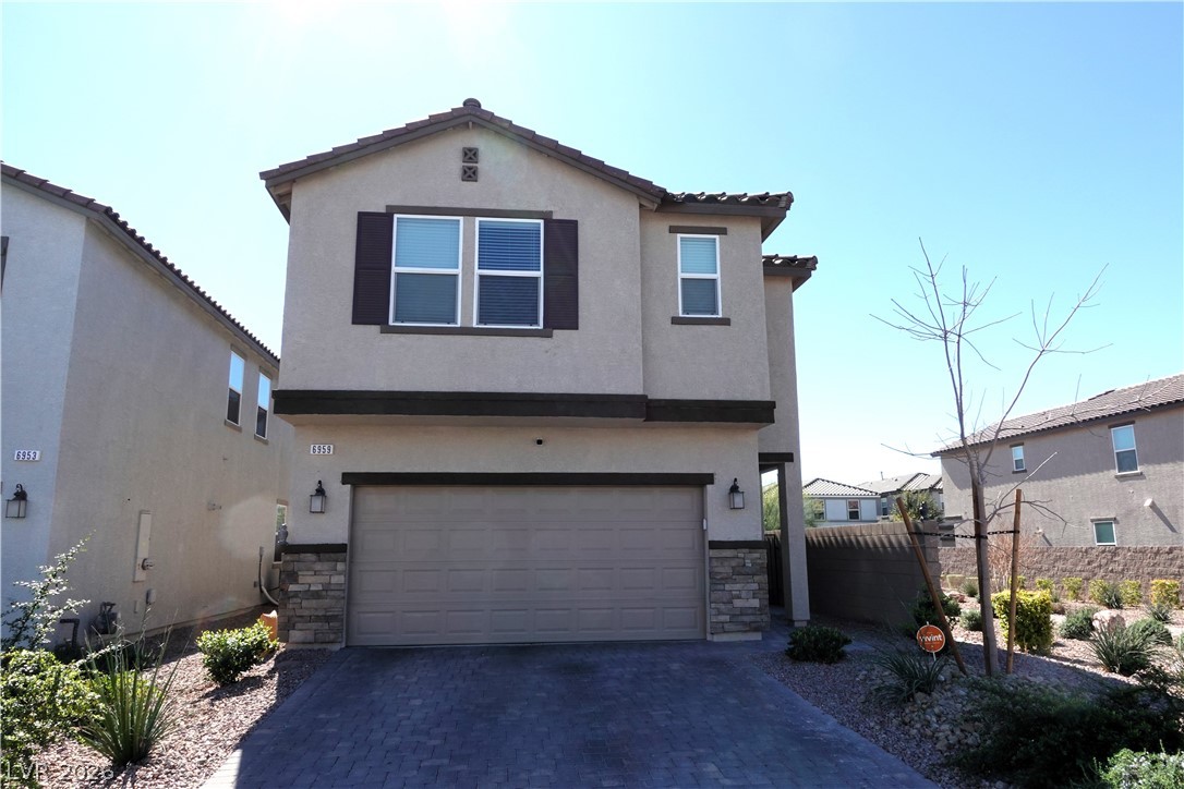 View of front of property featuring stone siding and stucco siding