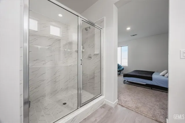 a bathroom with a shower and a glass door