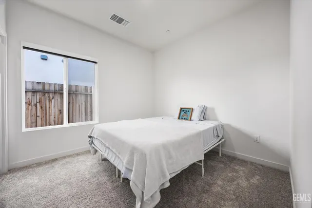 a bed sitting in a bedroom next to a window