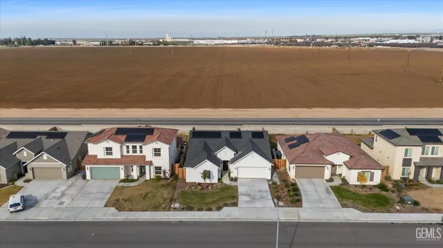 an aerial view of residential houses with outdoor space and ocean view