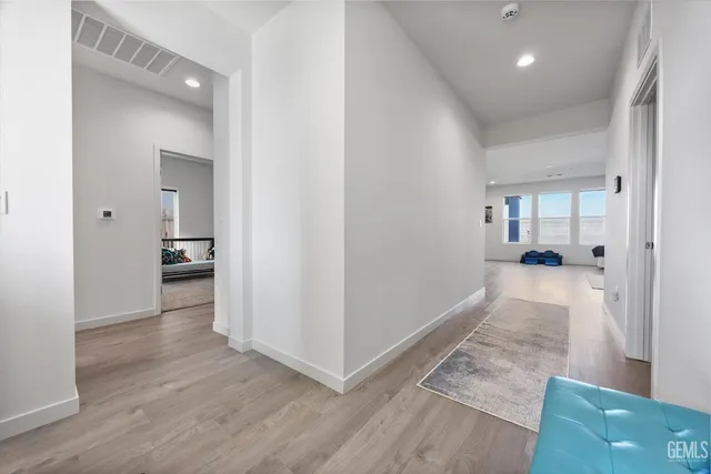 a view of a hallway view with wooden floor and a living room