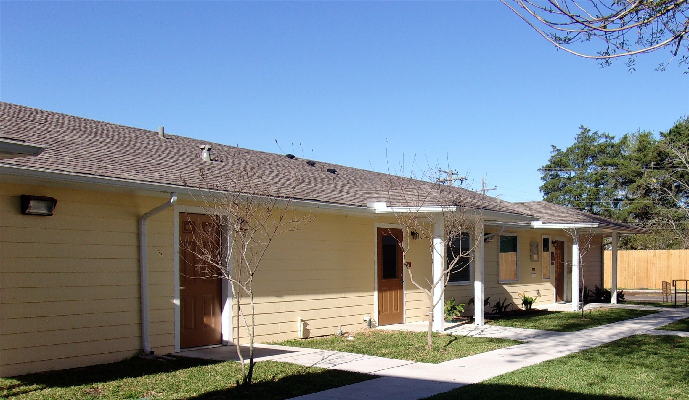 103 Cornwall Drive Victoria, TX 77904 - Photo 2 of 7 a view of a white house with large windows and a table and chairs