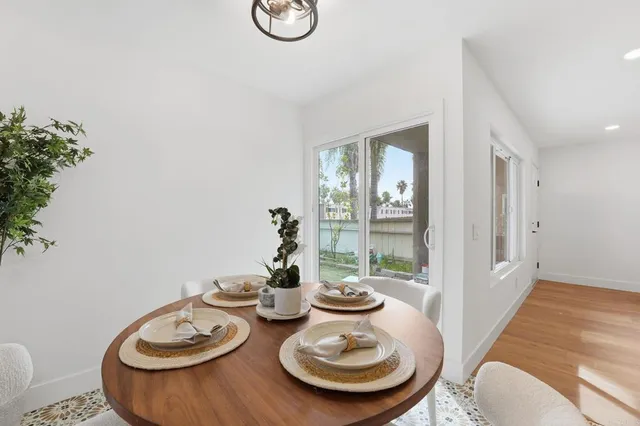 a table with chairs and a vase of flowers