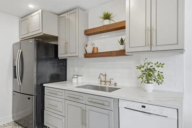 a kitchen with stainless steel appliances granite countertop white cabinets and a stove