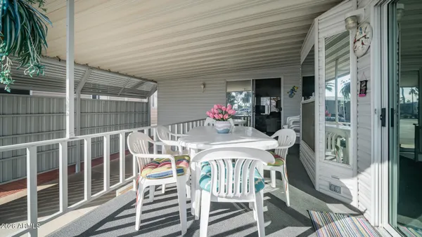 a view of a patio with a table and chairs and a barbeque