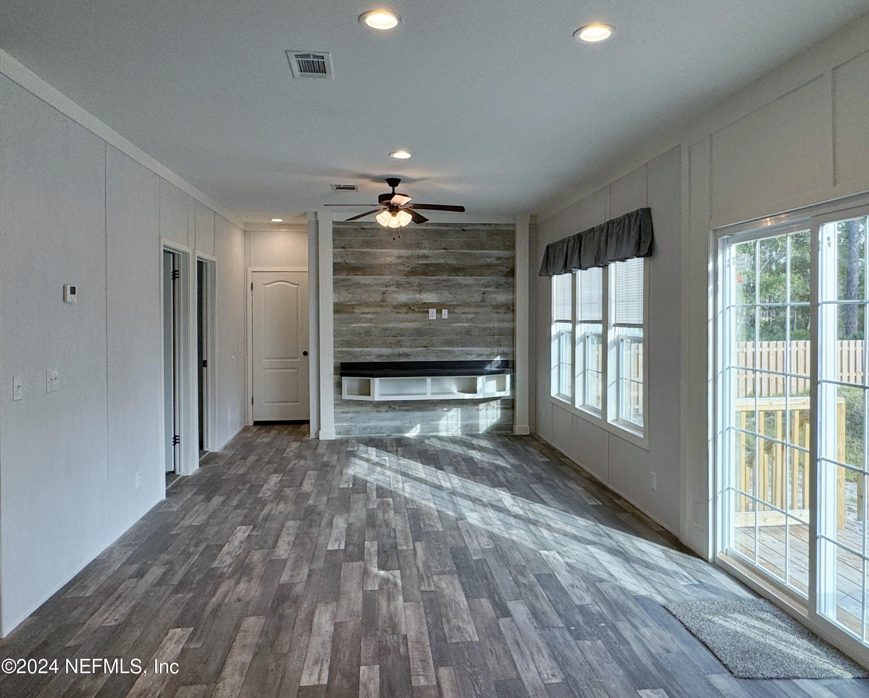 127 Domingo Road Satsuma, FL 32189 - Photo 4 of 18 a view of empty room with a fireplace and windows