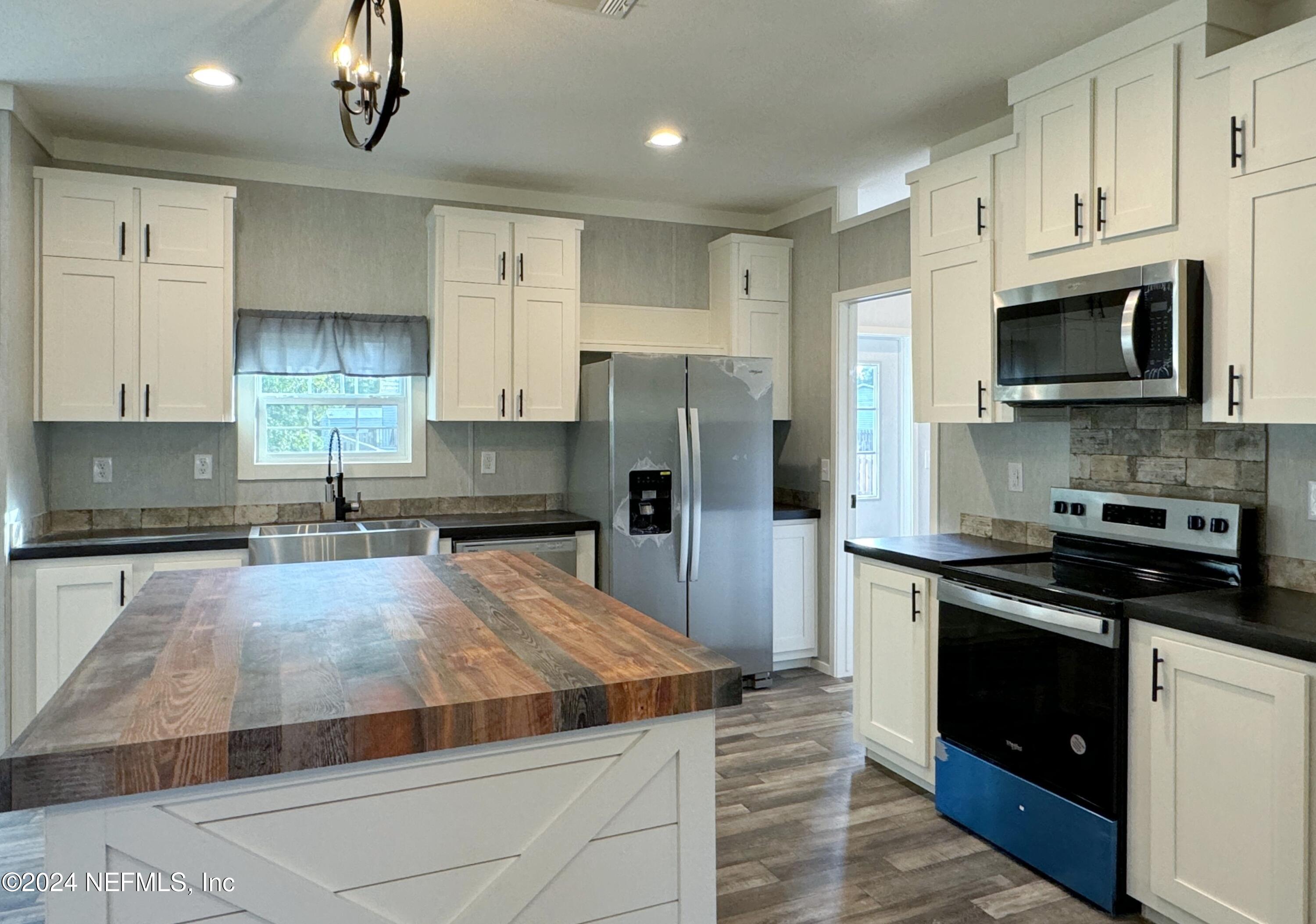 127 Domingo Road Satsuma, FL 32189 - Photo 9 of 18 a large kitchen with cabinets stainless steel appliances and a counter space