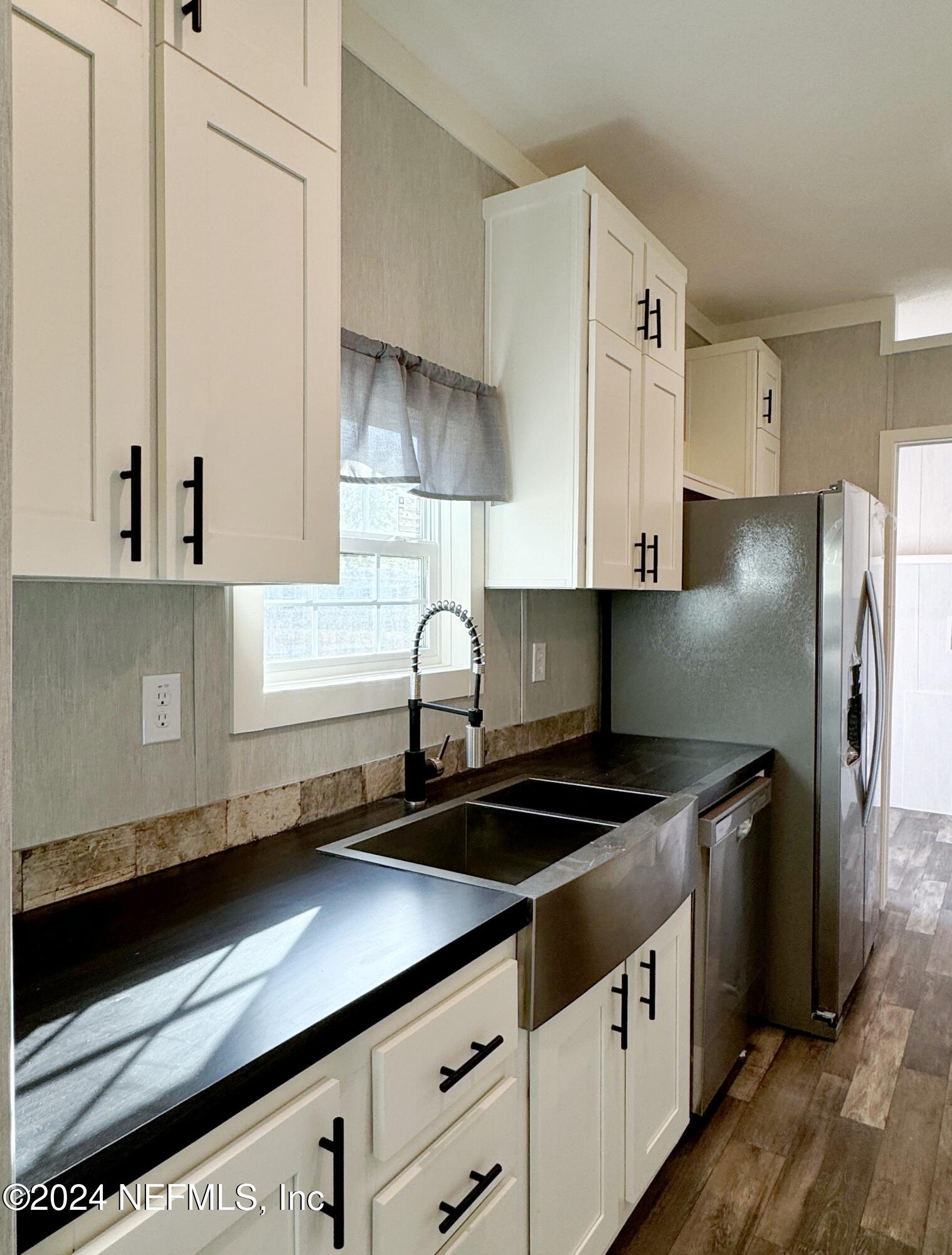 127 Domingo Road Satsuma, FL 32189 - Photo 10 of 18 a kitchen with stainless steel appliances a sink a stove a refrigerator and cabinets