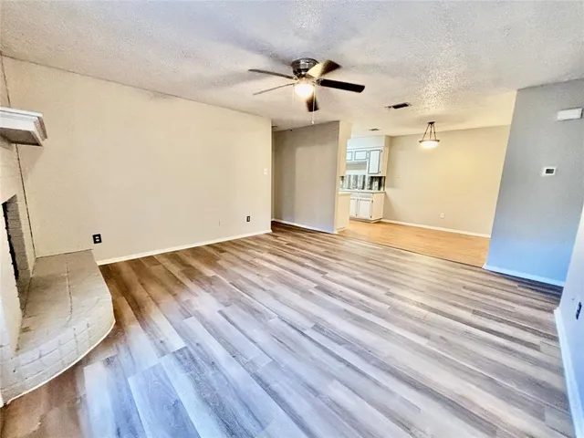 a view of a room with wooden floor and white walls