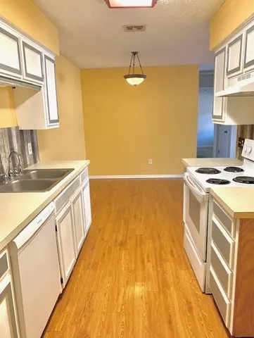 a view of a kitchen with wooden floor and a sink