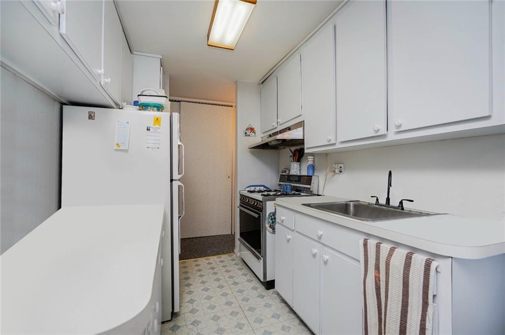 2475 West 16th Street, Unit 4K Brooklyn, NY 11214 - Photo 12 of 15 a kitchen with a sink a refrigerator and cabinets