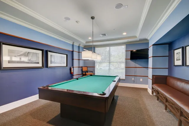 a room with furniture pool table and flat screen tv