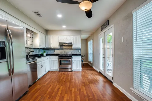 a kitchen with stainless steel appliances a refrigerator sink and microwave