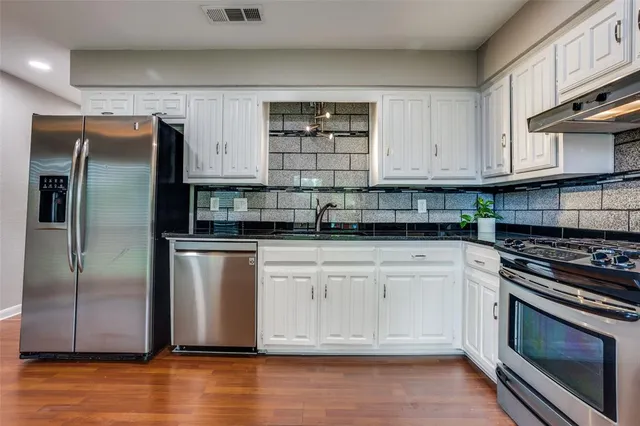 a kitchen with stainless steel appliances granite countertop a refrigerator sink and cabinets