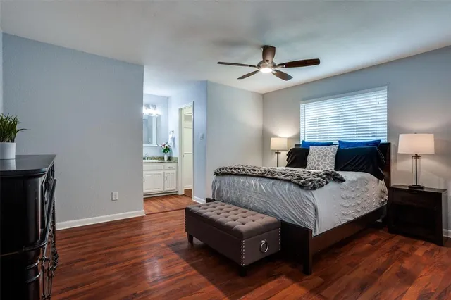 a bedroom with a bed lamp on table and a window