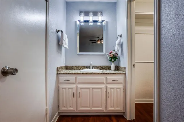 a bathroom with a granite countertop sink a mirror and a vanity