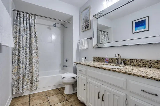 a bathroom with a granite countertop sink a toilet and a bathtub