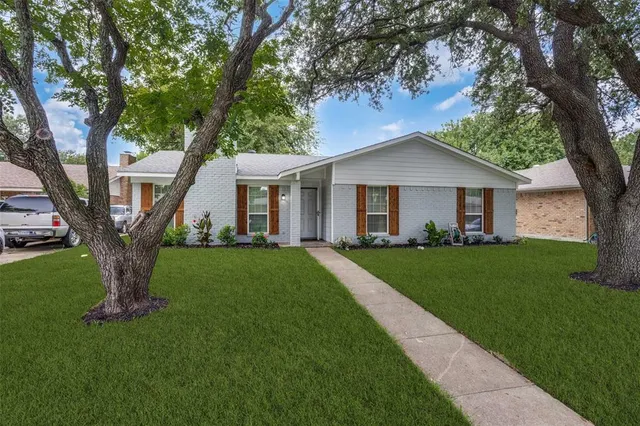 a front view of a house with a garden and yard
