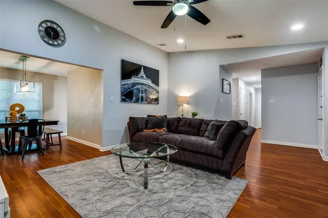 a living room with furniture and a wooden floor