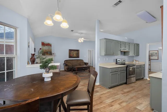 a kitchen with sink a refrigerator and chairs
