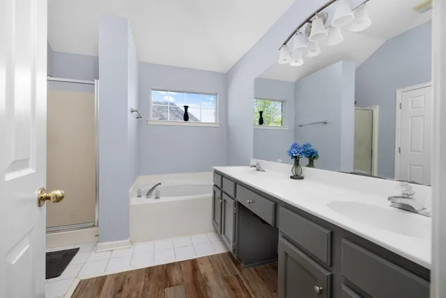 a bathroom with a tub sink and mirror