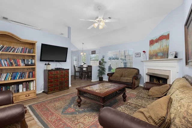 a living room with furniture a bookshelf and a flat screen tv