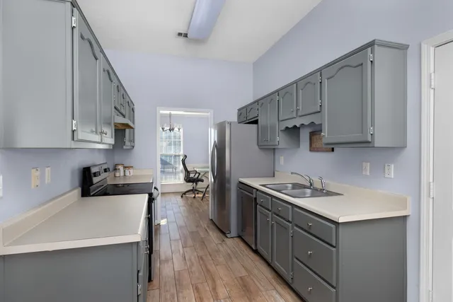 a kitchen with stainless steel appliances a sink stove and cabinets