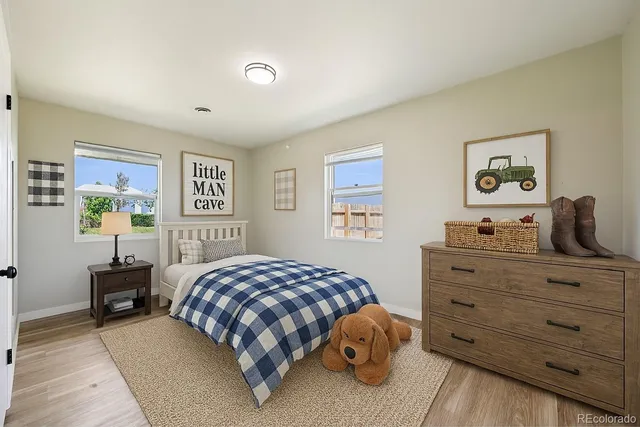 a bedroom with a bed and painting on the wall