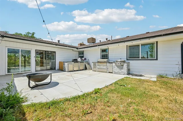 a front view of a house with a yard and more potted plants
