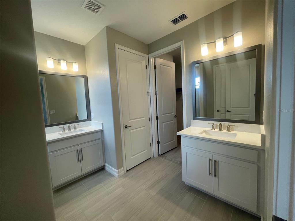 4596 Almada Lane Wesley Chapel, FL 33543 - Photo 16 of 56 a bathroom with a double vanity sink mirror and double