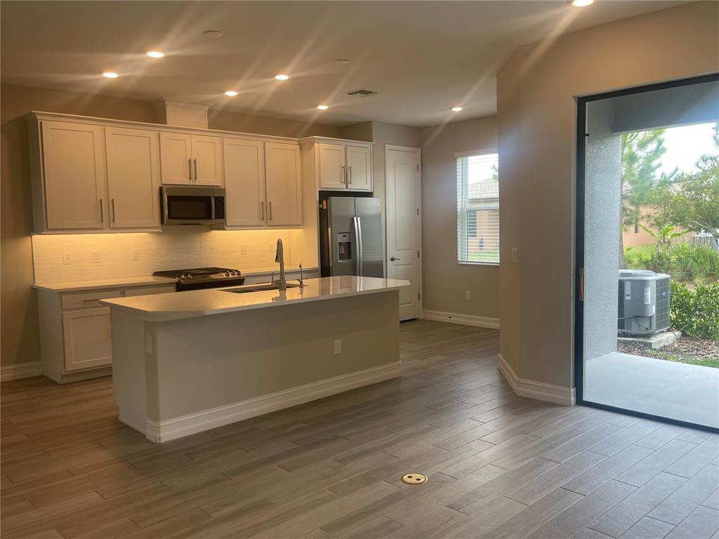 4596 Almada Lane Wesley Chapel, FL 33543 - Photo 4 of 56 a kitchen with granite countertop a stove and a refrigerator
