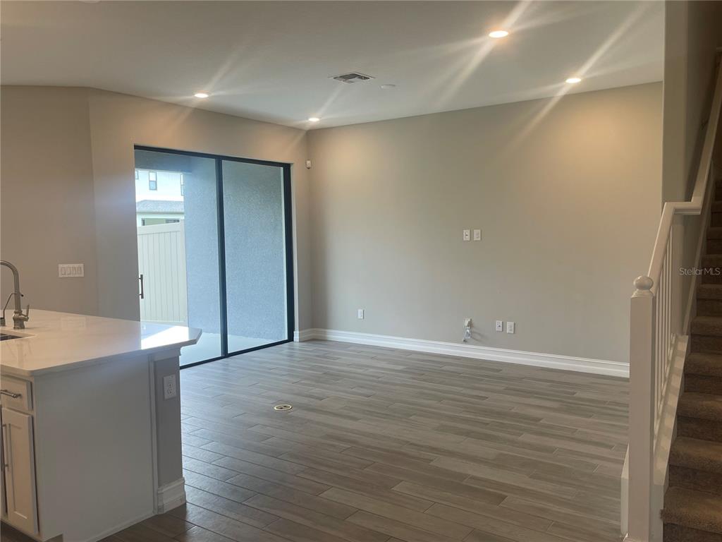 4596 Almada Lane Wesley Chapel, FL 33543 - Photo 7 of 56 a view of an empty room with wooden floor and a sink