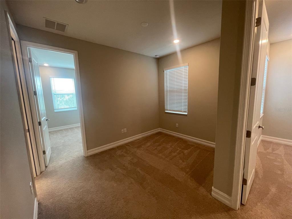 4596 Almada Lane Wesley Chapel, FL 33543 - Photo 9 of 56 an empty room with windows and closet