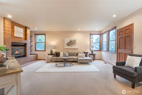 a living room with furniture fireplace and a large window