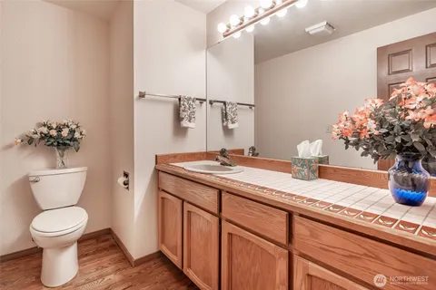 a bathroom with a granite countertop sink a toilet and a mirror