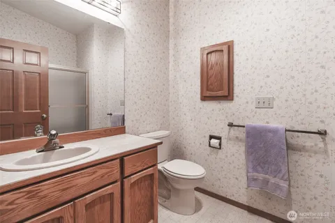 a bathroom with a toilet a sink and mirror
