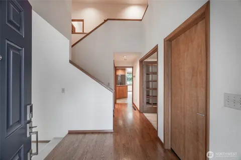 a view of a hallway with wooden floor and staircase