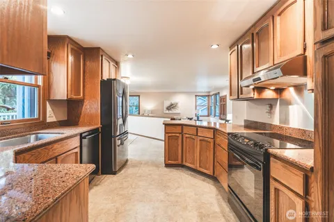 a kitchen with stainless steel appliances granite countertop a stove a sink and a refrigerator