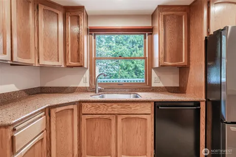 a kitchen with stainless steel appliances granite countertop a sink and a refrigerator
