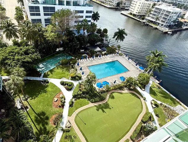 an aerial view of a swimming pool with outdoor seating
