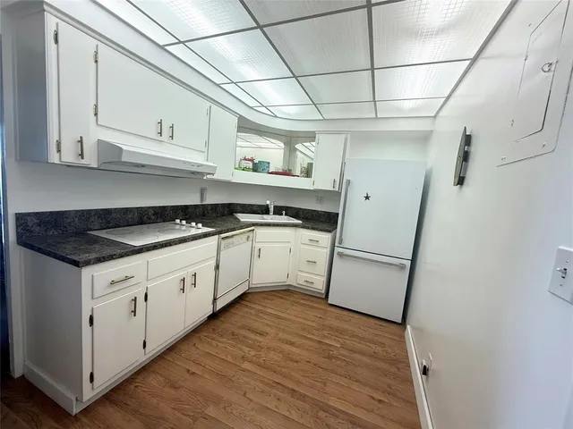 a kitchen with white cabinets and white appliances