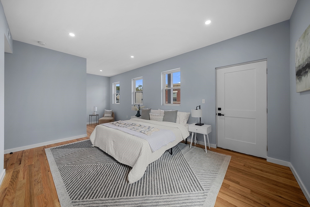 175 Howard Avenue, Unit 2 Boston, MA 02125 - Photo 19 of 26 a spacious bedroom with a bed and wooden floor